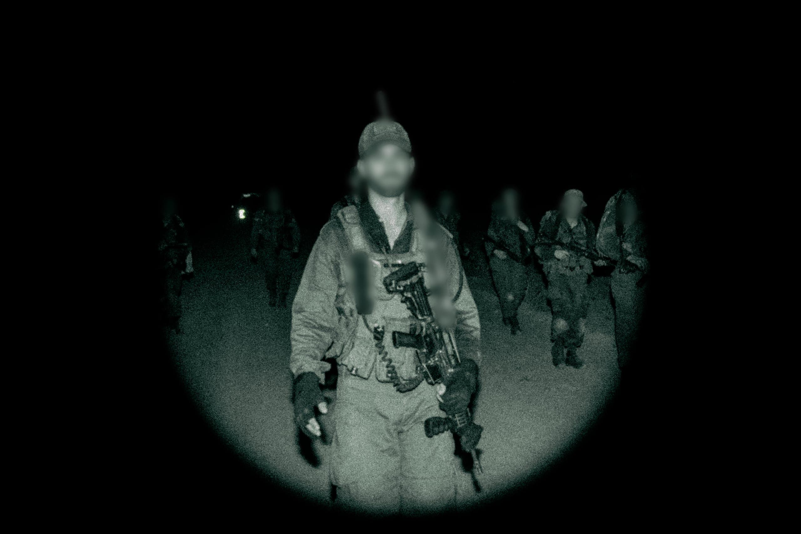 Soldiers on a night patrol, seen through a night-vision lens